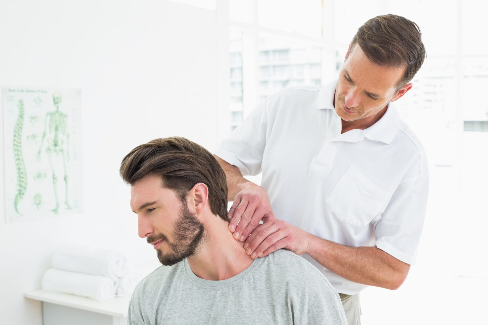 male-therapist-massaging-young-mans-neck